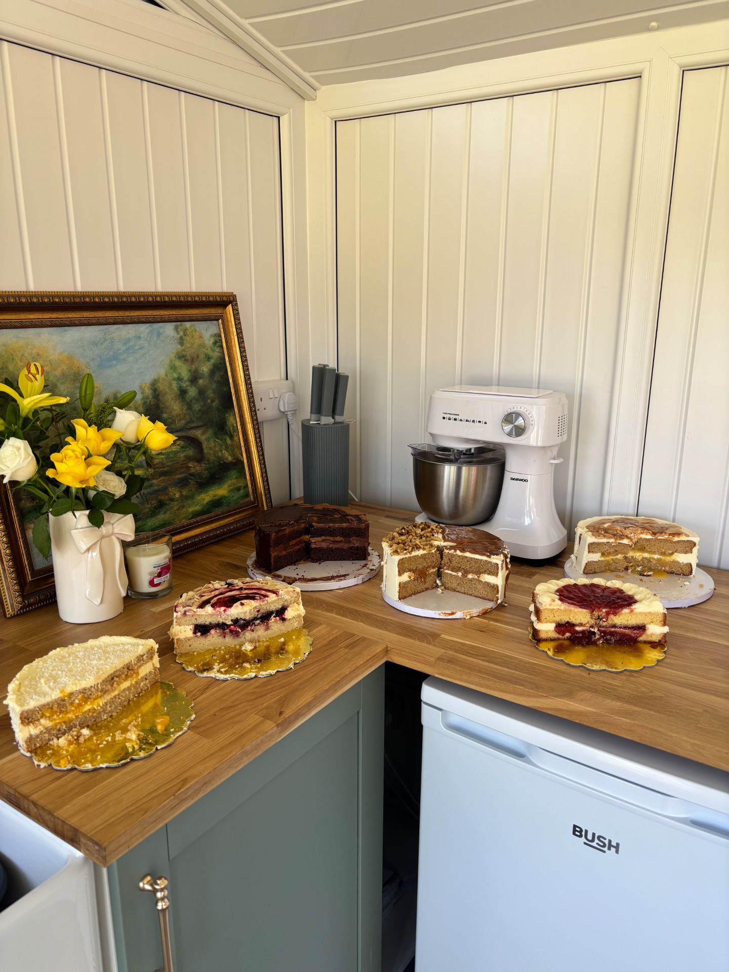 A spread of freshly baked cakes cut open on the bakery worktop