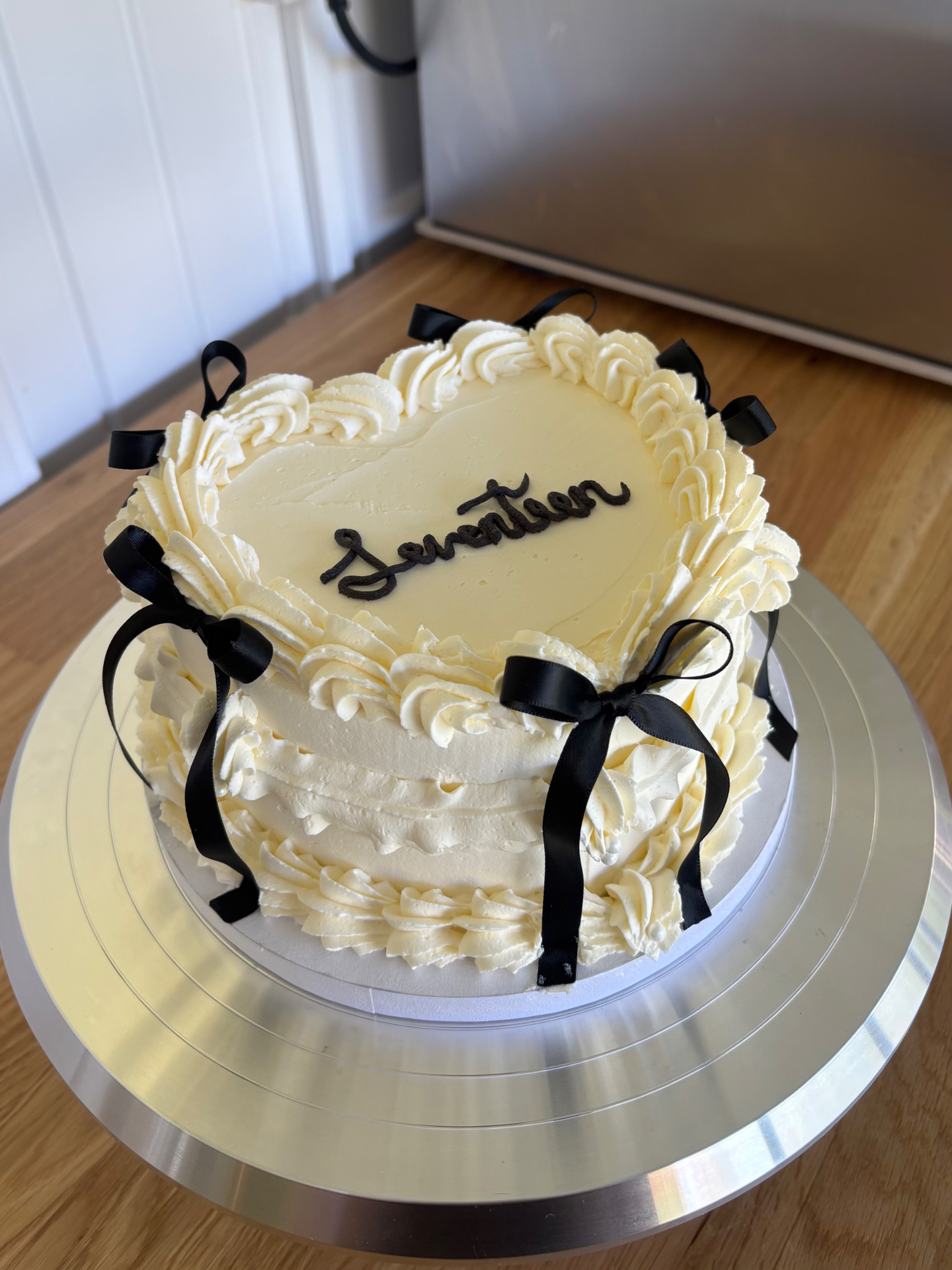 Pink heart-shaped birthday cake with ruffled buttercream, meringue kisses and pink sprinkles
