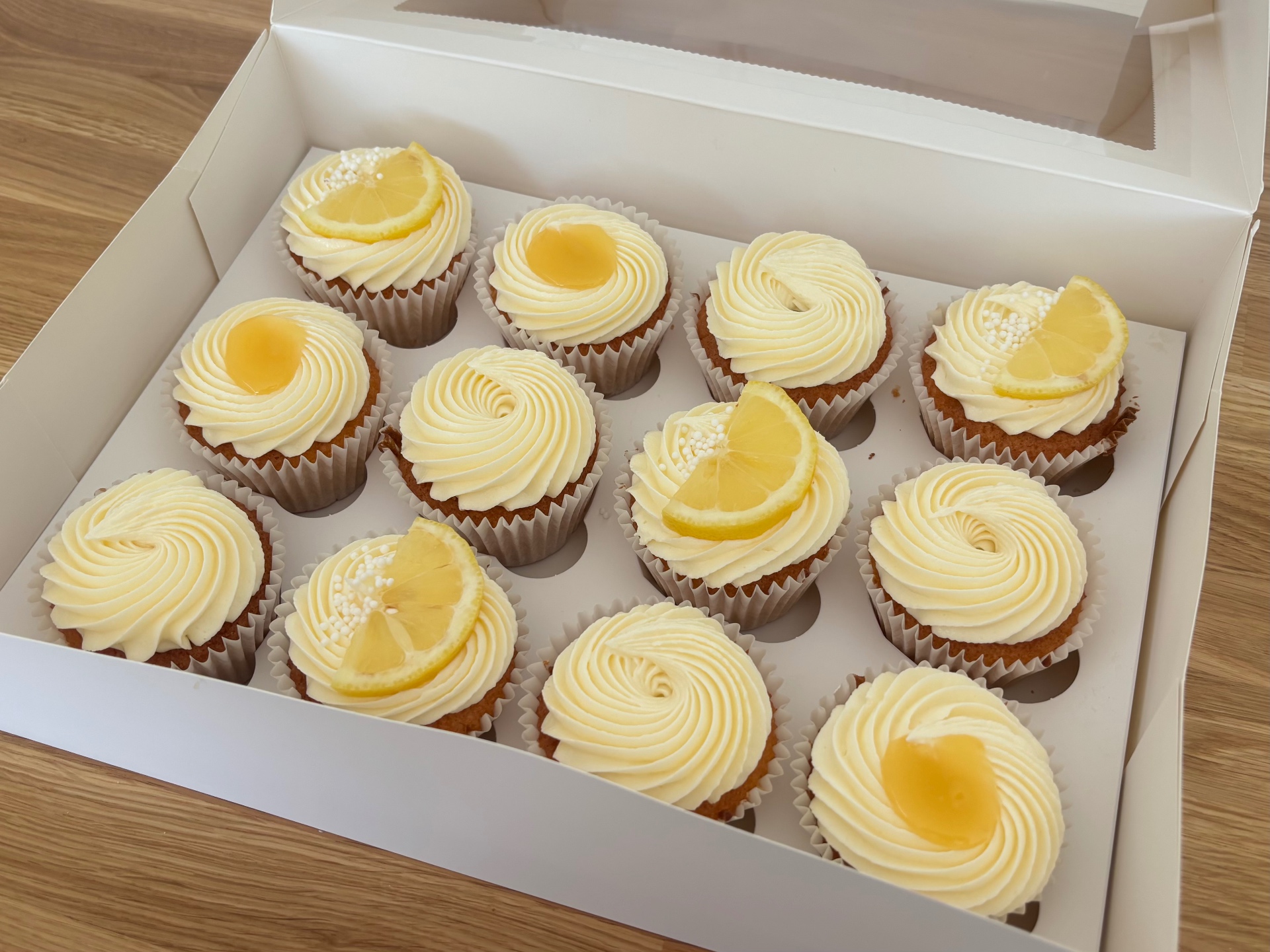 Box of twelve lemon cupcakes with buttercream swirls, lemon curd and lemon slices