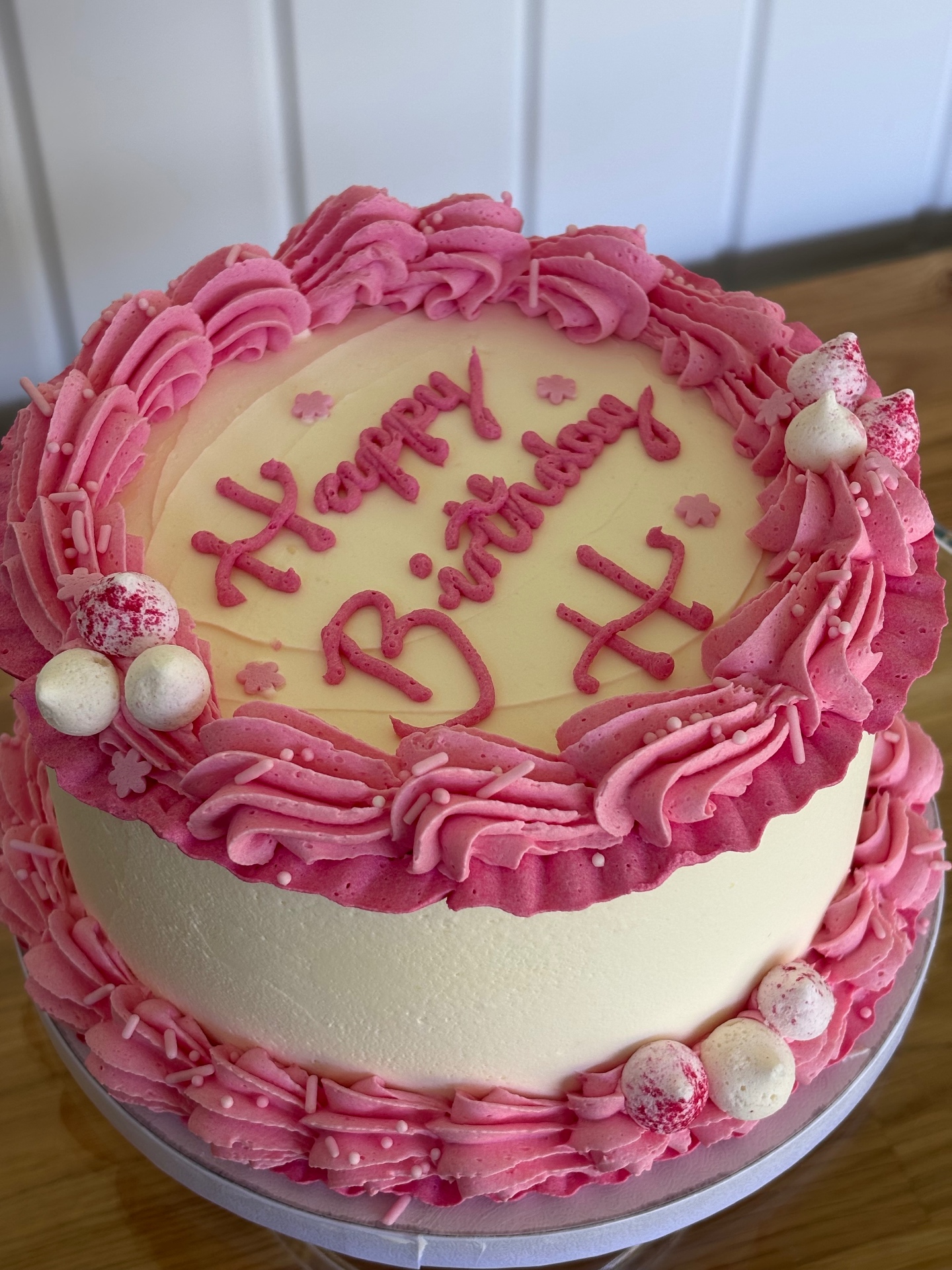 Ivory heart-shaped birthday cake with black ribbon bows and Seventeen piping
